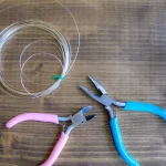 How to Choose Beading Thread, Wire, and Cord for Your Project Wire coils and jewelry pliers on a wooden table