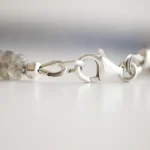 How to Finish Jewelry with Crimps, Knots, and Clasps Close-up of a bracelet clasp with chain and crimped end