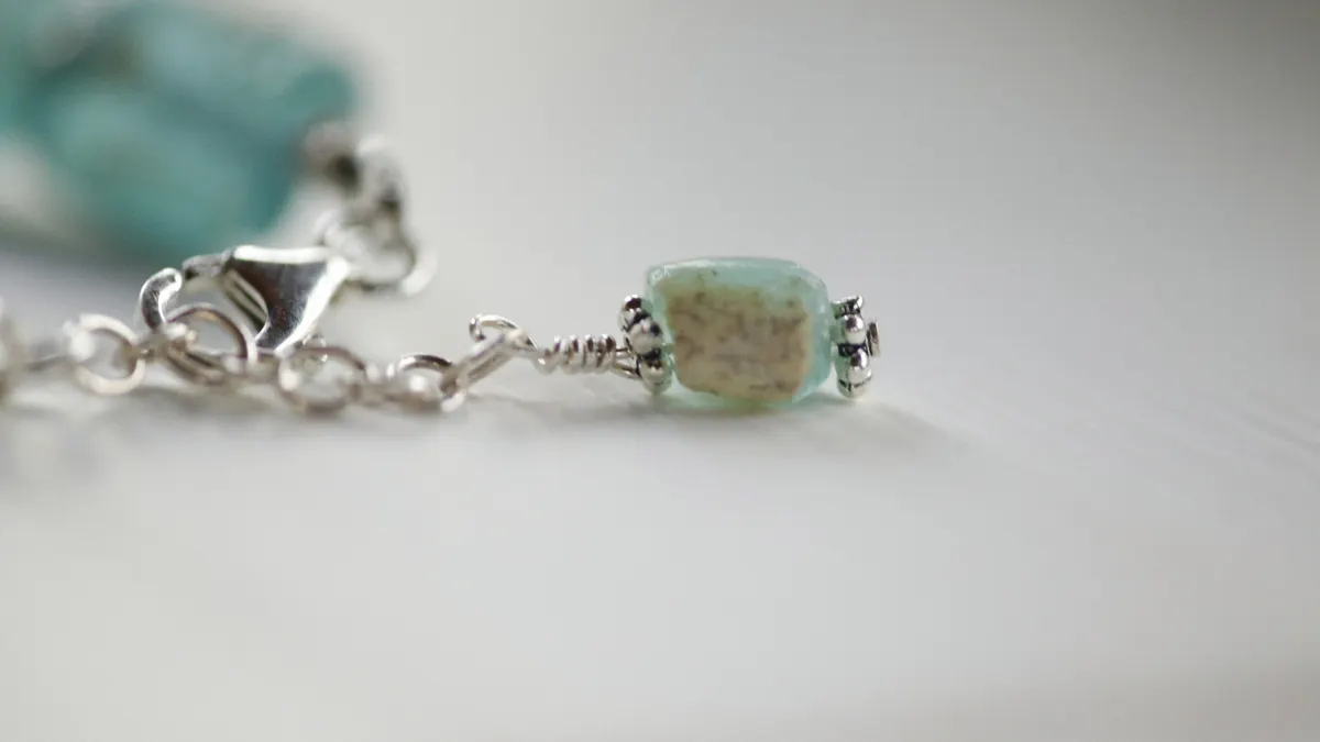Bracelet end with bead, crimp, and clasp close-up