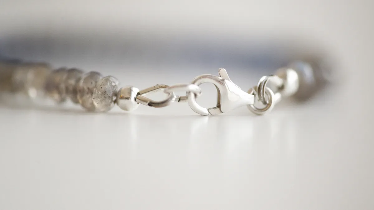 Close-up of a bracelet clasp with chain and crimped end